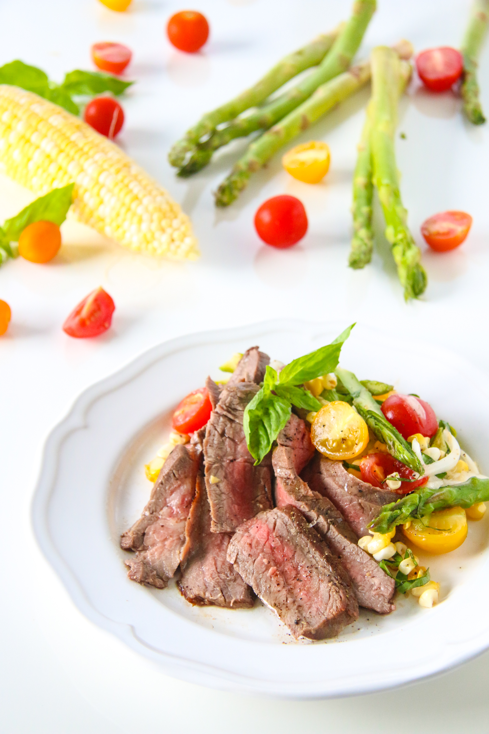 marinated flank steak with corn, asparagus, and tomato salad